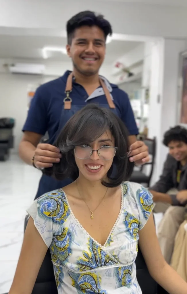 Clienta sonriendo con corte en capas y flequillo